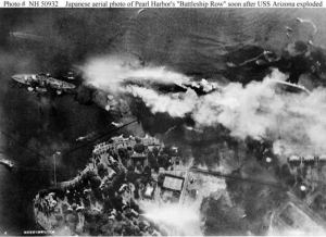 Pearl Harbor Attack on December 7, 1941. This aerial view shows the Nob Hill neighborhood fronting "Battleship Row." The photo was taken soon after USS Arizona was hit by bombs and her forward magazines exploded. Photographed from a Japanese aircraft. U.S. Naval History and Heritage Command Photograph.